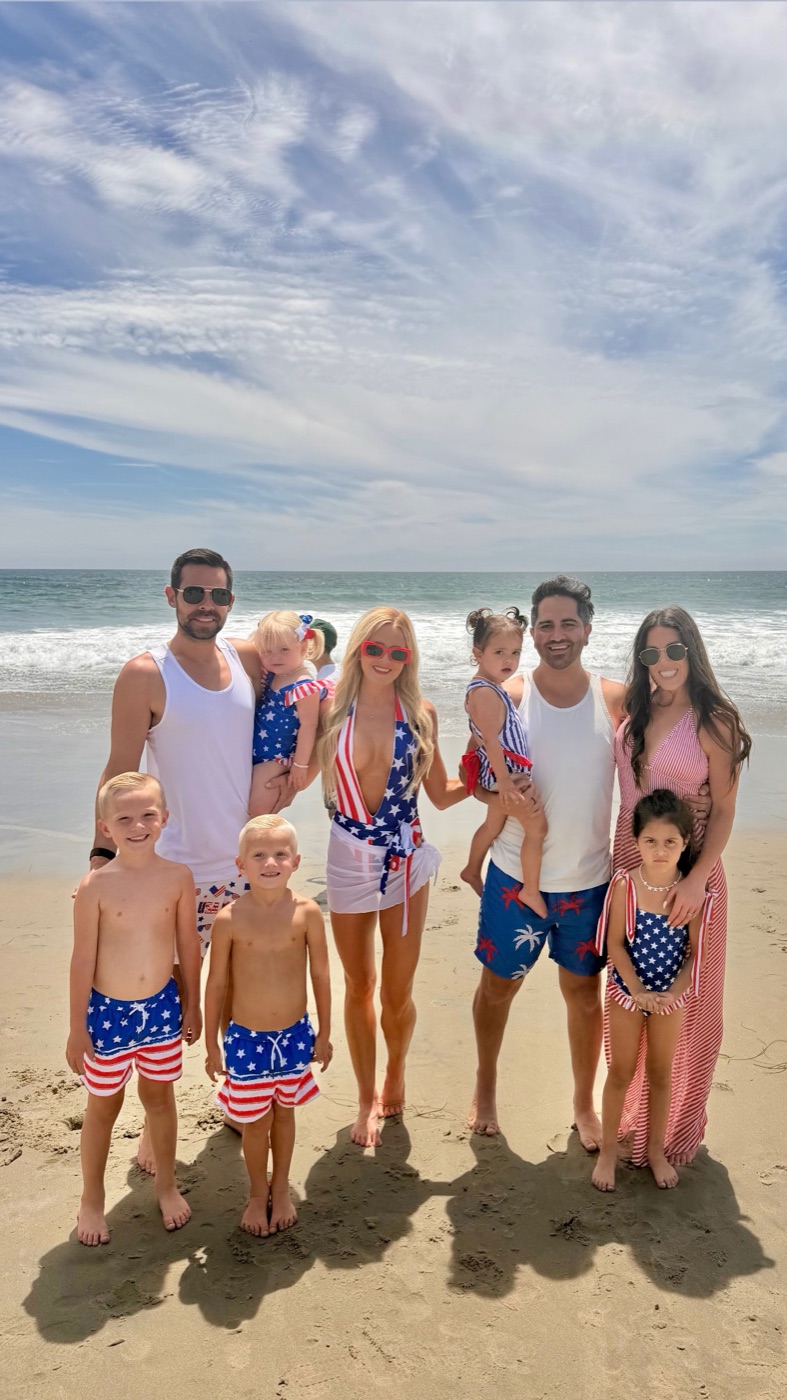 Both families in matching red, white, and blue on the beach at Dana Point, July 4th weekend 2026